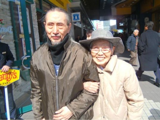 笑顔で肩を組む高齢者二人
