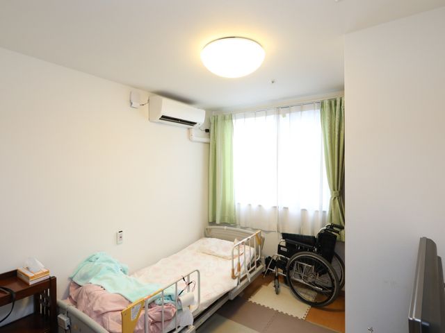 明るい個室の居室空間 居室 広々とした個室で、必要な家具が備わり、日の光が優しく差し込む心地よい空間です。車椅子も置ける広さがあり、個々のニーズに対応可能です。