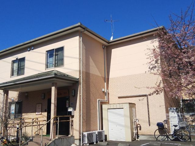 桜並木沿いの建物 外観 暖かな陽光が差し込む、桜の木が隣接する明るい建物です。新しい職場を探している方には、環境が一つの魅力となるかもしれません。