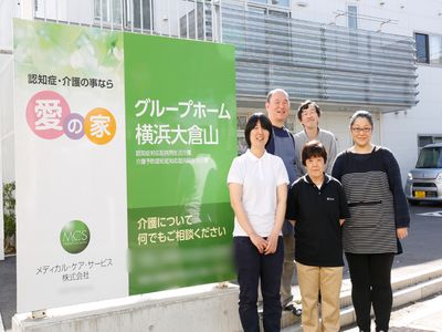 スタッフと看板の前