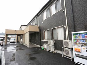 黒い壁の建物と駐車場