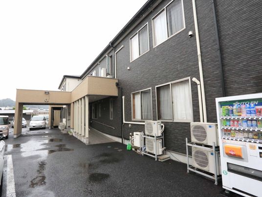 黒い壁の建物と駐車場