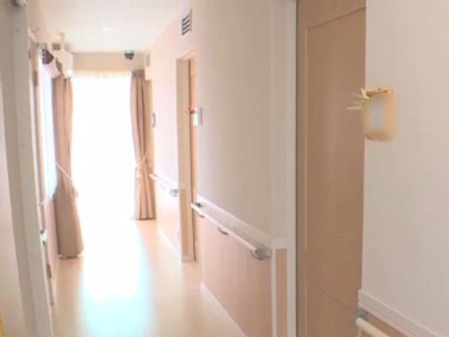 明るく清潔な廊下 廊下 広々とした廊下は柔らかな光で照らされ、温もりを感じるデザインが特徴です。手すりが設置され、歩行時の安全も配慮されています。