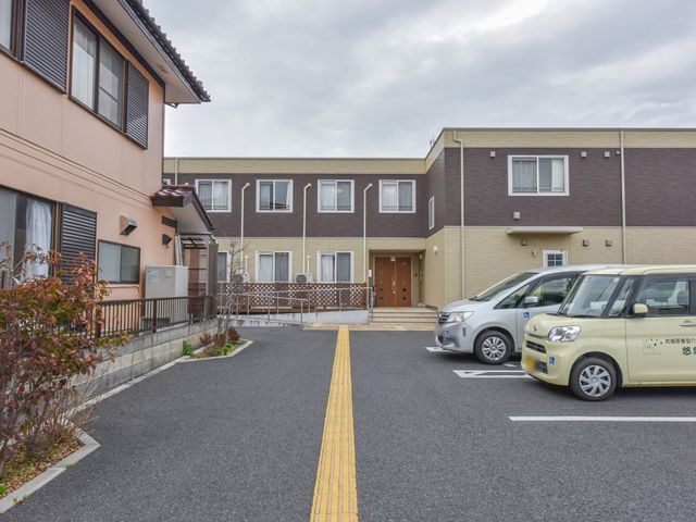 茶色の建物の外観 外観 広々とした駐車スペースがある、落ち着いた色調の建物です。職員や来訪者の利便性を考慮した設計になっています。