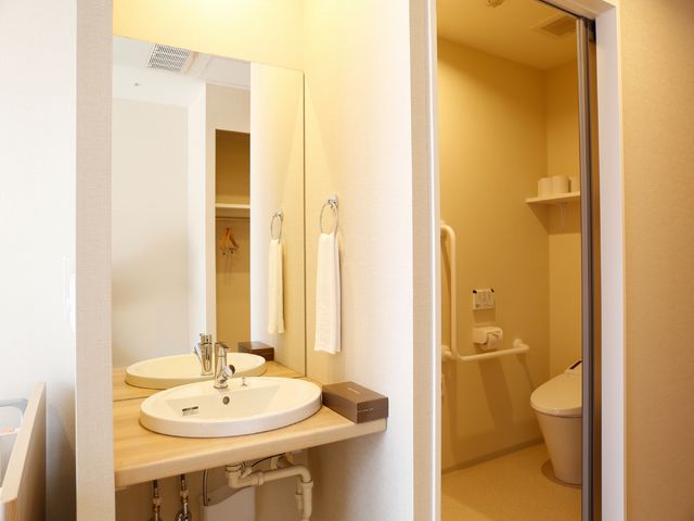 清潔な洗面台とトイレ 居室の洗面所 広めの洗面スペースと、手すり付きの安全なトイレ設備が整えられており、日々の生活を快適に支えます。