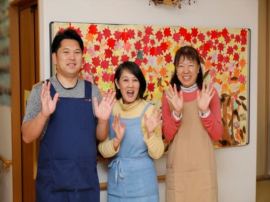 スタッフが笑顔で手を振る