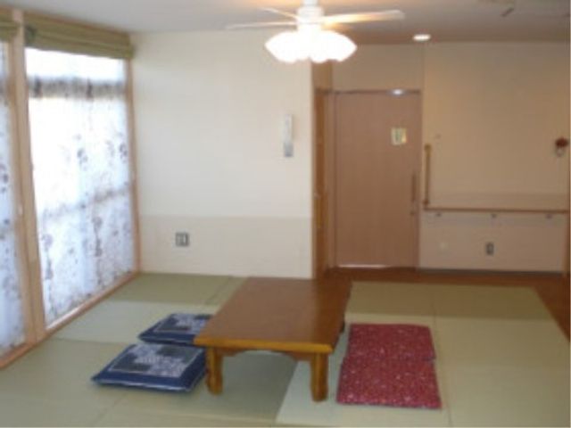 明るい和室の居室 和室 広々とした和室は明るく、日々の憩いの場として利用できます。ざぶとんが敷かれた低めのテーブルは、心地よいひとときを提供します。