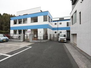 青いラインの建物外観