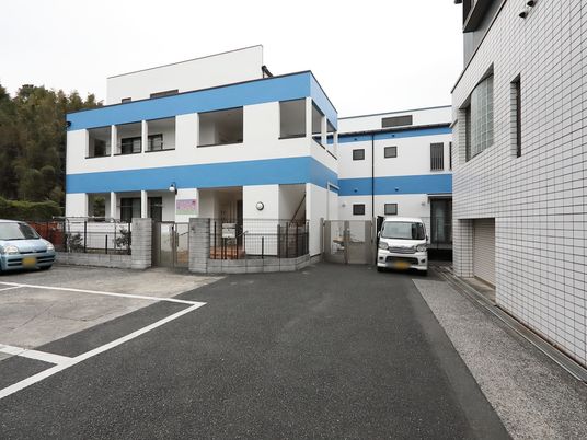 青いラインの建物外観