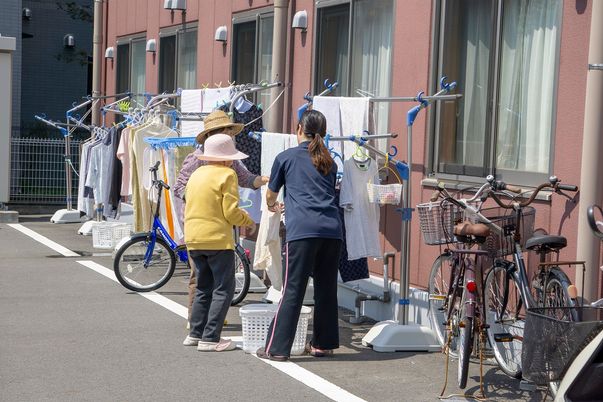 洗濯をする人々とスタッフ