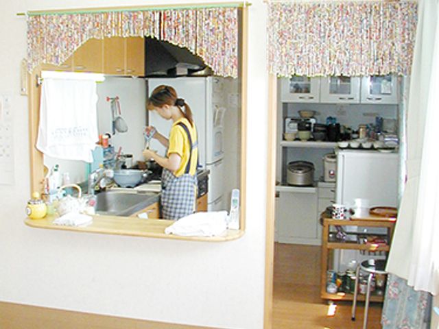 キッチンで作業する人 キッチン ゆったりとしたキッチンで、調理の様子を見ていただけます。作業スペースも充実しており、料理を楽しむことができる空間です。