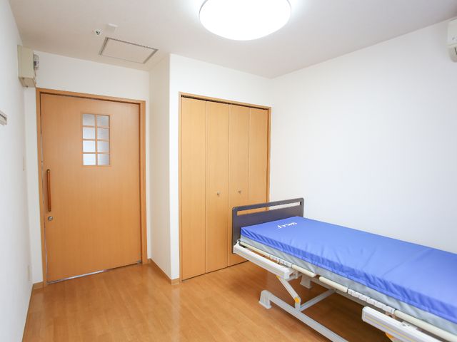 清潔な居室 居室 手すり付きのベッドが設置され、落ち着いた色合いでまとめられた居室です。広々とした空間は日々の快適な生活をサポートします。