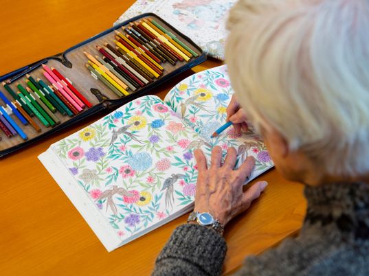 色鉛筆で塗り絵する高齢者