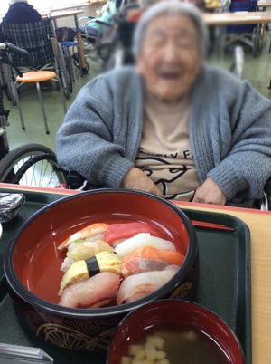 笑顔の利用者と寿司の食事