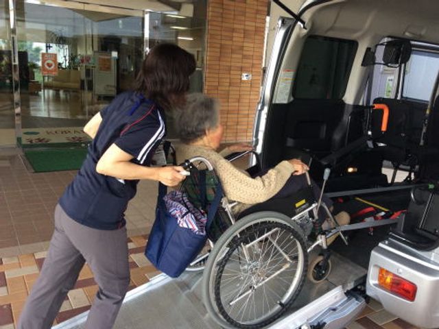 車椅子での移動サポート エントランス スタッフが車椅子の方を安全に送迎しています。サポート体制が整っていることがわかります。