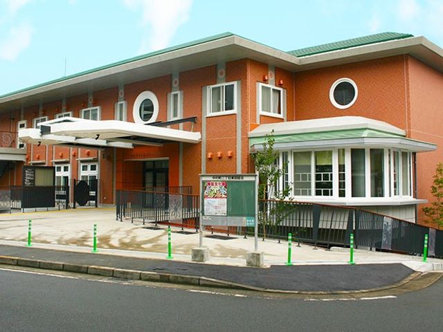 緑に囲まれた建物外観 外観 広々とした敷地に立地し、アクセスも便利です。働きやすい環境を感じることができます。