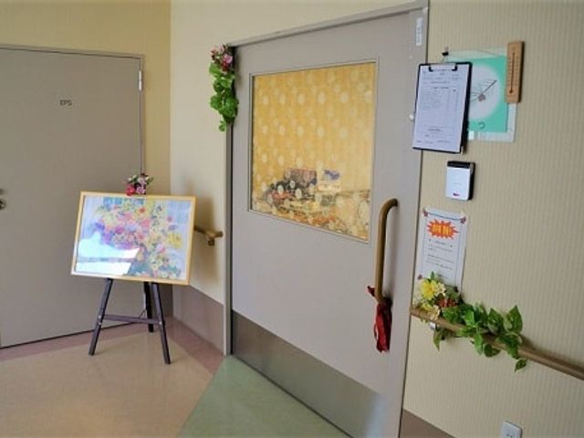 明るい廊下のドア 廊下 彩り豊かな飾りが施され、明るい雰囲気のドア前です。絵画が壁に掛かっています。