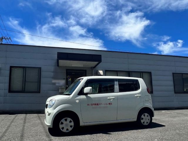 明るい外観 外観 車の停まる広いスペースがある施設の前です。明るい空とともに、清潔感のある眺めです。