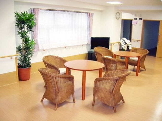 ラウンジの円卓と椅子 リビングルーム 開放感のあふれるラウンジで、訪れる方々がゆったりと寛げる空間を提供しています。椅子は移動が容易で、くつろぎや交流の場として最適です。