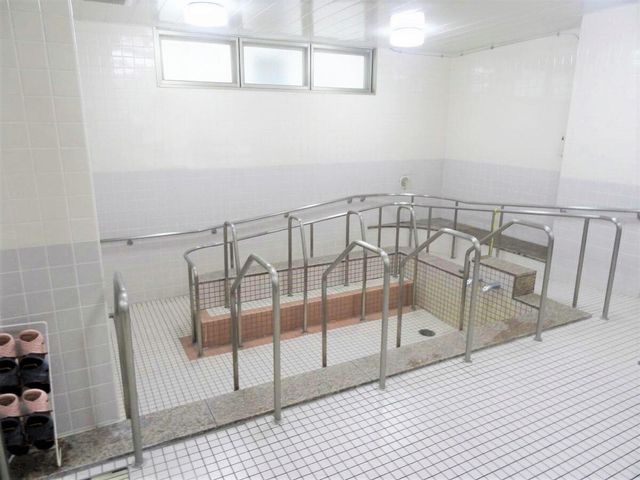清潔な浴室の内観 大浴場 広々とした安全配慮のための手すり付き浴室です。安心して日々の身体のケアができる環境が整っています。