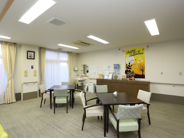 多目的スペースの明るい室内 リビング 季節の飾りつけがされた、ゆったりとした多目的スペースです。テーブル周りでの交流や情報の確認もできます。