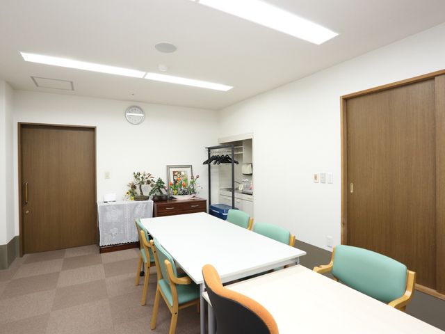 清潔感のある居室 談話室 整然と配置されたテーブルと椅子が並ぶ、明るく広々としたスペースです。心地よい作業環境を提供しています。