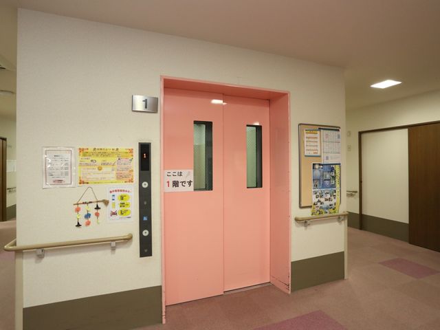 ピンクのエレベーター扉 エレベーター 清潔感のあるエレベーター前は、案内表示も充実しており利用しやすい作りです。