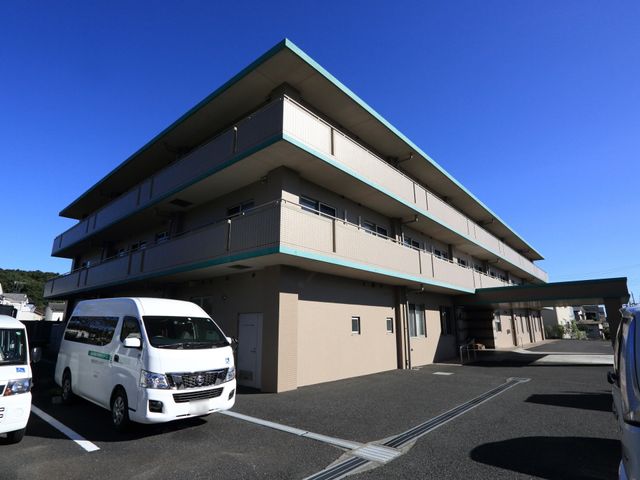 広々とした建物の外観 外観 青空の下、清潔感のある建物が訪れる人を温かく迎えます。ゆとりの駐車スペースも完備しており、アクセスも便利です。