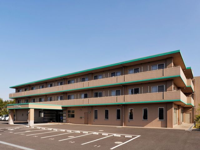 三階建ての明るい外観 外観 広々とした駐車場が確保された、清潔感のあふれる建物です。就業を検討される方にとって、明るく開放感のある環境が魅力的です。