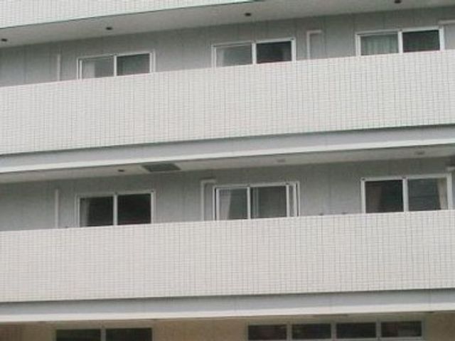 白い壁の建物外観 外観 清潔感のある白い壁の建物です。多くの明るい窓があり、開放感が感じられる作りになっています。