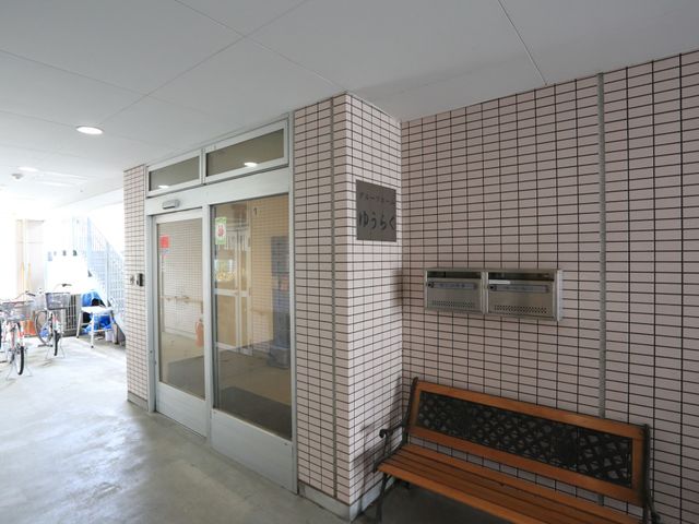 エントランスにあるベンチ 玄関 スッキリとしたエントランスには待合用のベンチが配され、来訪者を温かく迎えます。通路も広く、快適な出入りが可能です。