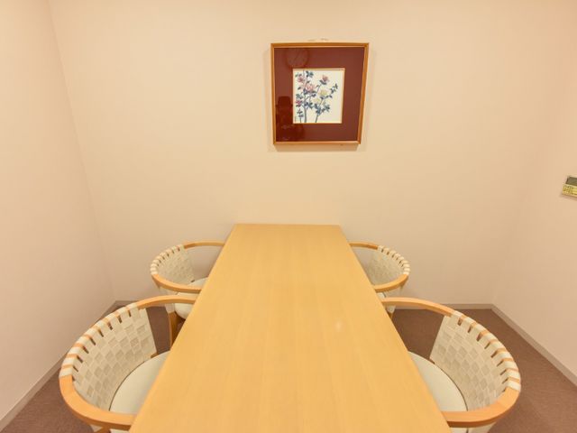 暖かみのある居室のテーブル 小部屋 ゆったりとしたテーブルが中心にある居室です。壁にはアートが飾られ、落ち着いた雰囲気を醸し出しています。