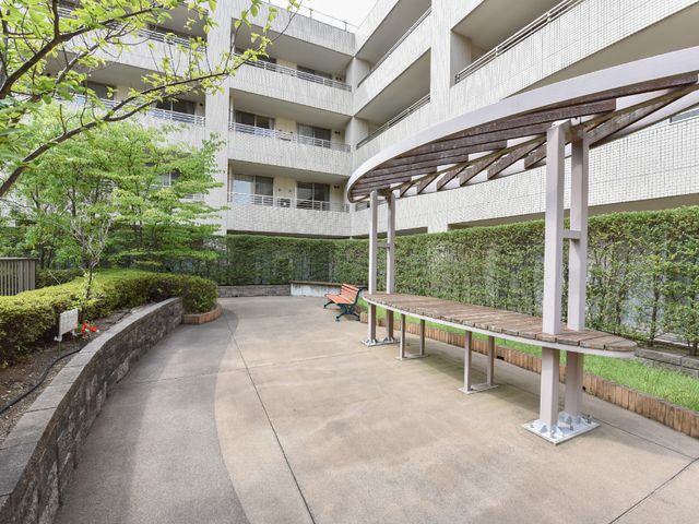 中庭のベンチと緑 散歩道 ゆったりとした中庭には長い木製のベンチが並び、木々の緑が心を和ませてくれます。静かな時間を過ごす場として最適です。