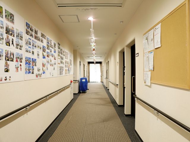 廊下に飾られた写真壁 通路 廊下には様々な活動の写真が飾られ、暖かい雰囲気を醸し出しています。働く際には、ここでの充実した日々を支えるやりがいを感じられるでしょう。