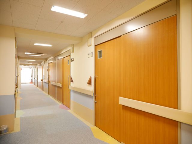廊下の手すりと扉 廊下 明るく清潔感のある廊下が広がり、手すりが設置されているため、歩行補助が必要な方も安心です。