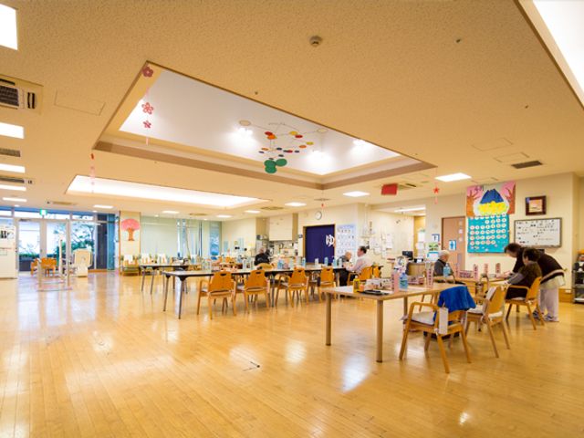 広々した明るいダイニング ダイニングルーム 広いダイニングルームでは、椅子に座る方々がゆったりとした時間を過ごしています。窓からの自然光が心地よい空間です。