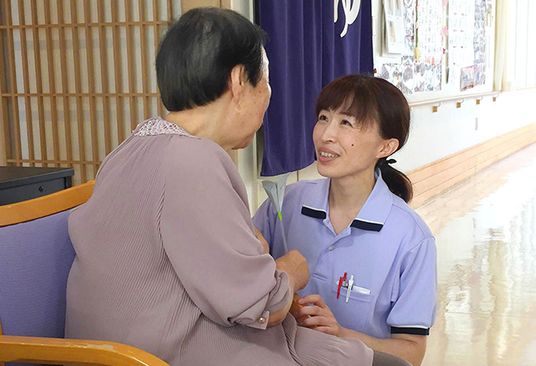 廊下で会話する利用者と職員