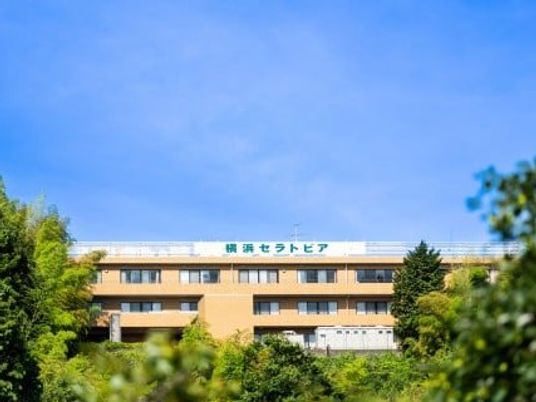 緑に囲まれた建物の外観  
