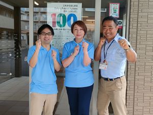 笑顔の職員3人の玄関前