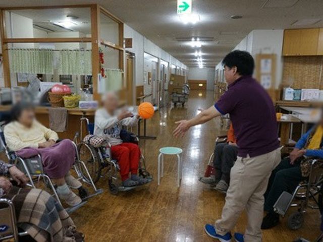 車椅子の方々と活動するスタッフ 廊下 自然な雰囲気でスタッフが車椅子の方々と楽しそうに活動をしています。働きやすい環境です。