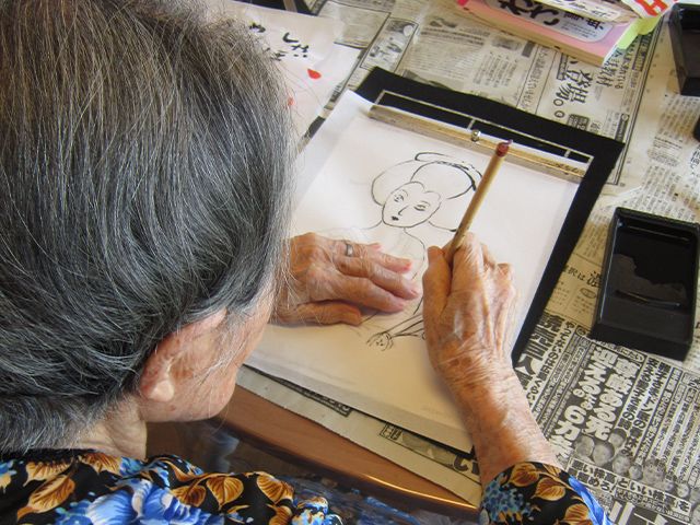 絵を描く風景 多目的室 暖かい雰囲気の中で、入居者が創作活動を楽しめる環境です。集中して絵を描く様子が見られます。
