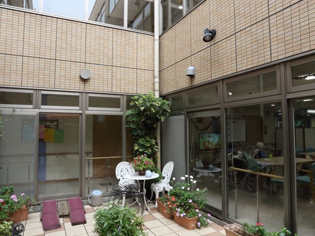中庭にある植物と椅子 中庭 緑豊かな中庭があり、憩いの場として利用できます。休憩時には心地よい自然の空間でリラックスしていただけます。