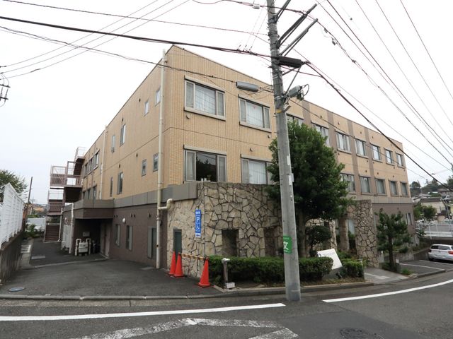 黄色い壁の建物外観 外観 立地がよく、アクセス便利な建物です。広々とした前面道路も魅力の一つです。
