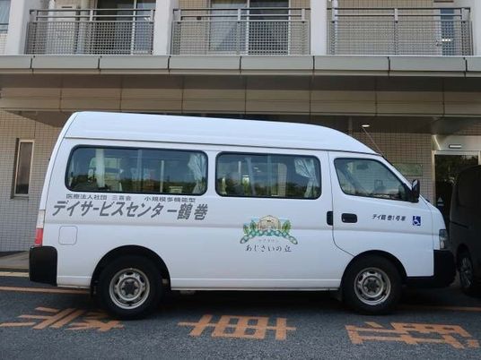 送迎車が停まる施設外観  