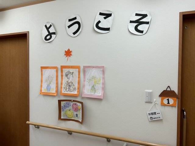歓迎の掲示物廊下 廊下 木目調の手すりが設置された温かみのある廊下です。壁には歓迎の絵が飾られています。