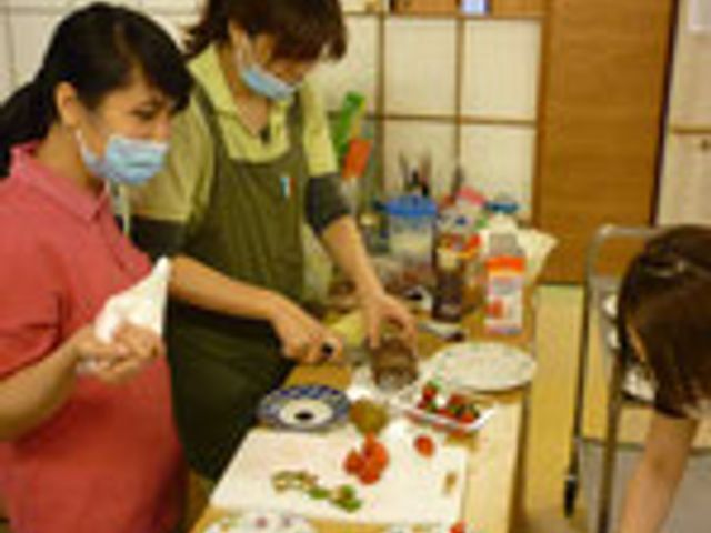 調理作業の様子 キッチン スタッフが協力して料理を準備している場面です。和気あいあいとした雰囲気で作業しています。