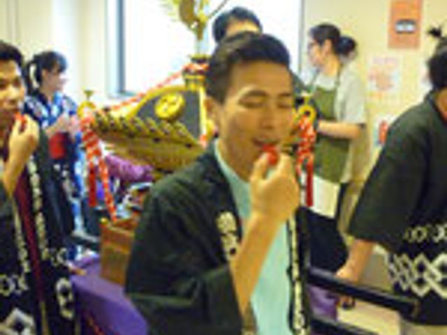 祭りの風景、廊下 廊下 賑やかな祭りの様子が見られ、参加者同士の交流が盛んです。スタッフと利用者の笑顔が印象的です。
