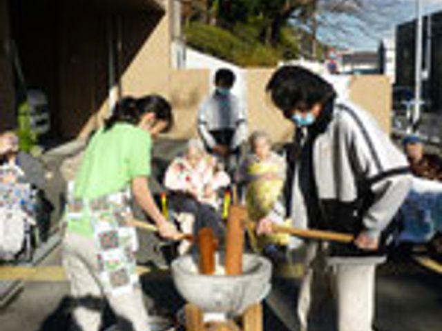 餅つきイベントの様子 外観 天気の良い日に行われる餅つきは、交流を深める良い機会です。スタッフも利用者も楽しそうです。