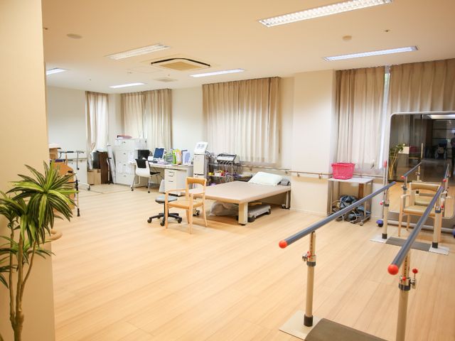 広々としたリハビリ室 共有スペース 明るい天井と床が特徴的な機能訓練スペース。専門の設備を備え、利用者様の体力向上をサポートいたします。