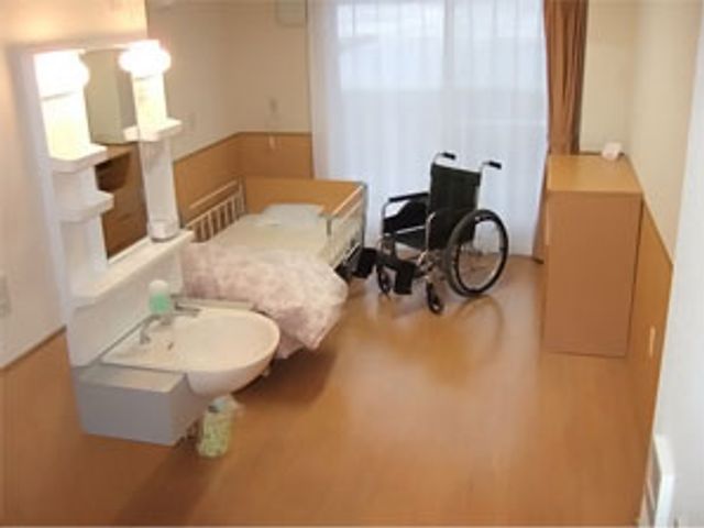 車椅子のある居室 居室 広々とした居室には、温かみのある色調の床と壁が落ち着いた雰囲気を演出しています。車椅子利用者にも配慮された設計です。